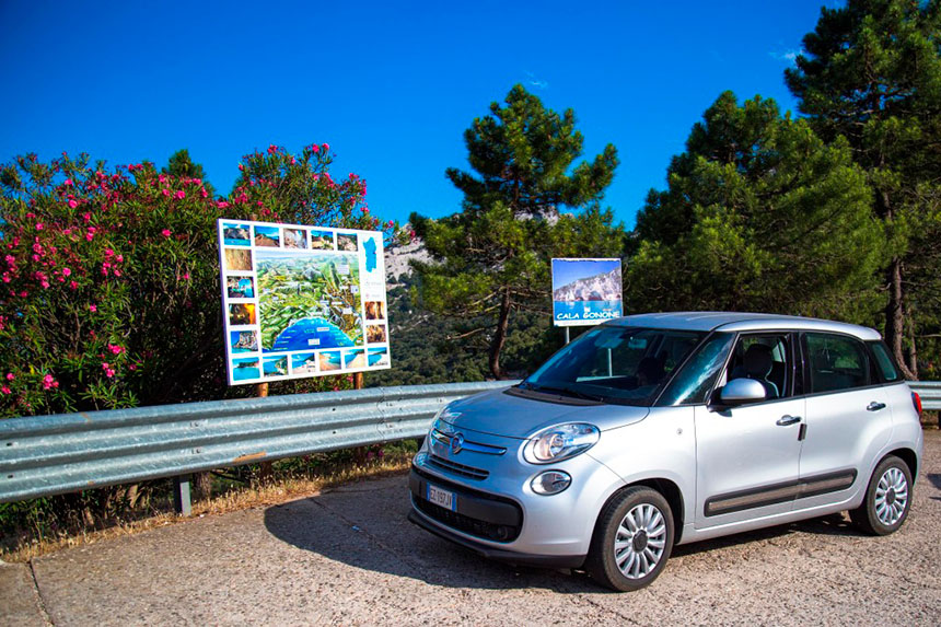 nosso carro alugado na Sardenha, em frente aos mapas de praias